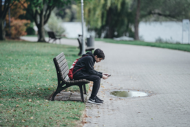 Adolescent sitting alone on a park bench